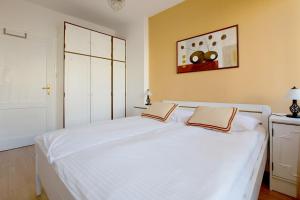 um quarto com uma cama branca com duas almofadas em Apartment Cvetje em Zagreb