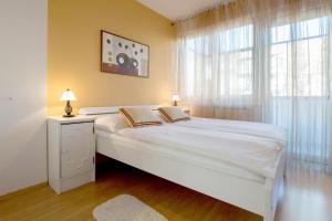 a bedroom with a large white bed and a window at Apartment Cvetje in Zagreb