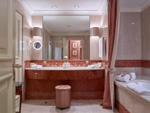 a bathroom with a tub and a large mirror at Grand Hotel Wien in Vienna