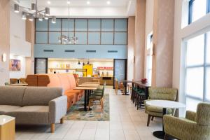 a lobby with tables and chairs and a cafeteria at Hampton Inn & Suites Addison in Addison +8 photos