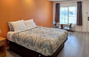a bedroom with a bed and a table with chairs at Rodeway Inn Alameda-Oakland in Alameda