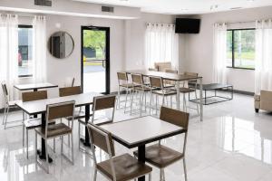 a dining room with tables and chairs and a tv at Sleep Inn & Suites Peoria North in Peoria