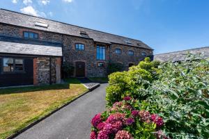 an old brick building with flowers in front of it at Duchy - Treworgie Barton Cottages in Bude