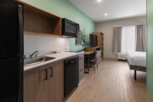 a small kitchen with a sink and a microwave at ECHO Suites Extended Stay by Wyndham Houston Katy West in Katy +14 photos
