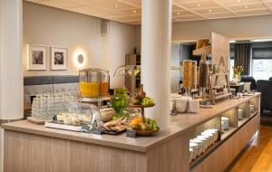 a buffet line with food and drinks on a counter at elaya hotel hannover city, Trademark by Wyndham in Hannover +30 photos