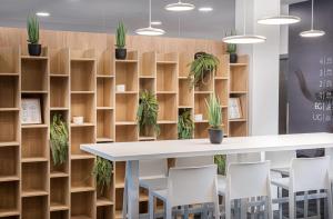 a conference room with a table and chairs and plants at elaya hotel augsburg, Trademark by Wyndham in Augsburg