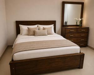a bedroom with a large bed with a dresser and a mirror at Oval View Residencies in Yakbedda +54 photos