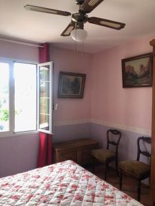 a bedroom with a bed and two chairs and a ceiling fan at Domaine Sagittaires in Le Cannet-des-Maures