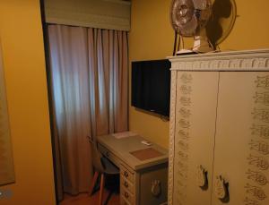 a room with a desk with a fan and a computer at Hotel Vitoria in Santarém +1 photo