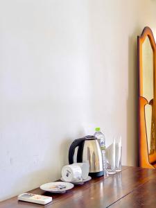 a tea kettle and cups on a wooden table at Splendid Lake View Safari Lodge in Udawalawe