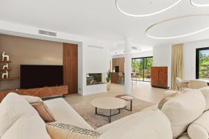 a living room with white furniture and a flat screen tv at Villa Augusta in Tourrettes