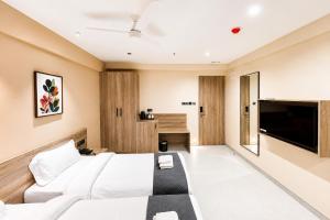 a bedroom with a bed and a flat screen tv at Rivotel The Luxury Hotel in Chākan