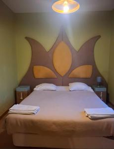 a bedroom with a large bed with a large headboard at Hotel Vitoria in Santarém