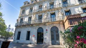 a white building with a balcony on top of it at The Originals Boutique, Le Grand Hôtel Molière, Pézenas in Pézenas