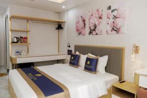 a bedroom with a bed with blue and white pillows at Sunrise Hotel Phước Kim in Bạc Liêu