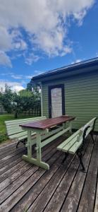 a picnic table and a bench on a wooden deck at Elva südalinna kodumajutus in Elva