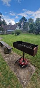a grill with a box on top of it next to a bench at Elva südalinna kodumajutus in Elva +2 photos