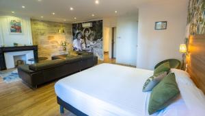 a bedroom with a large bed and a couch at The Originals Boutique, Le Grand Hôtel Molière, Pézenas in Pézenas +58 photos