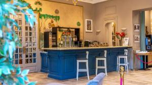 a blue bar in a room with stools at The Originals Boutique, Le Grand Hôtel Molière, Pézenas in Pézenas