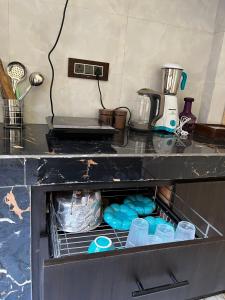 a kitchen counter with a drawer with dishes in it at Man Mauji Villa in Kasol +26 photos