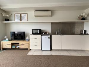 a kitchen with a white refrigerator and a tv at Absolute Waterfront Magnetic Island in Nelly Bay