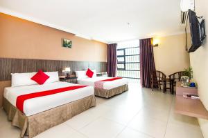 a hotel room with two beds and a television at Hotel O Crystal City Hotel in Kuantan
