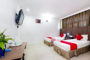 a hotel room with two beds and a television at Hotel O Crystal City Hotel in Kuantan