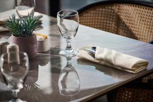 a table with two wine glasses on top of it at Harris Hotel & Conventions Sunshine Penang in Ayer Itam