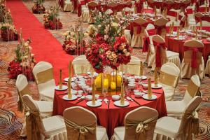 a table set up for a wedding with a red table cloth at Harris Hotel & Conventions Sunshine Penang in Ayer Itam