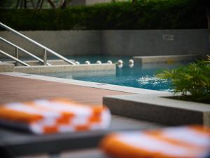 a swimming pool with a wooden deck and a swimming pool at Harris Hotel & Conventions Sunshine Penang in Ayer Itam