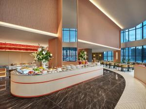 a hotel lobby with a buffet line with tables at Harris Hotel & Conventions Sunshine Penang in Ayer Itam +48 photos
