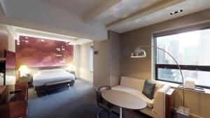 a hotel room with a bed and a table at Hyatt Grand Central New York in New York