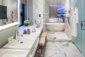a bathroom with two sinks and a tub at Hyatt Grand Central New York in New York +103 photos