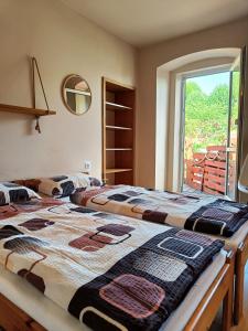 two beds in a room with a window at Apartamenty i pokoje gościnne "Wacuś" in Srebrna Góra