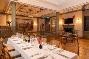 a dining room with tables and chairs and a fireplace at Hilton London Hyde Park in London