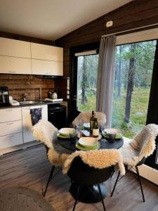 a kitchen with a table and chairs and a kitchen with a window at Borealis Village XXL |Sauna|WiFi|Ylläs|Aurora in Äkäslompolo +19 photos