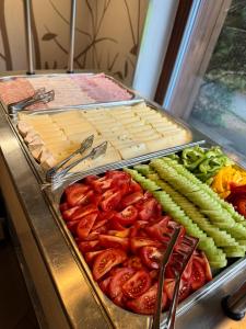 a buffet of food with tomatoes and vegetables at Horský hotel Lorkova vila in Čeladná