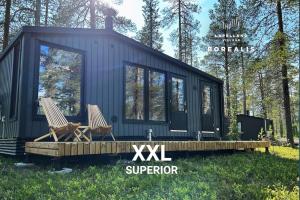 a tiny house in the woods with two chairs at Borealis Village XXL |Sauna|WiFi|Ylläs|Aurora in Äkäslompolo