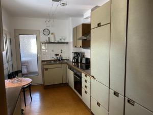 a kitchen with white cabinets and a table in it at Ferienwohnung Anke Kaufmann in Miltenberg