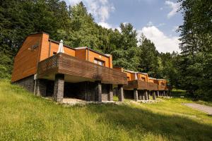 a row of houses on a hill with trees at Horský hotel Lorkova vila in Čeladná