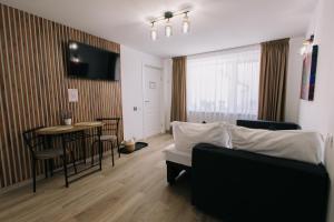 a living room with a couch and a table at RR House Apartments in Râşnov