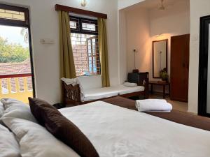 a bedroom with two beds and a window at Fatima Guest House in Baga