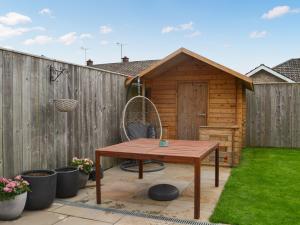 a backyard patio with a table and a shed at Oceans 44 in Bridlington