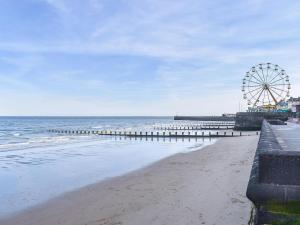 a beach with a ferris wheel and the ocean at Oceans 44 in Bridlington +18 photos