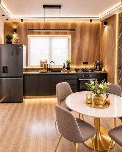 a kitchen with a table and chairs and a refrigerator at Maison Royale in Otopeni