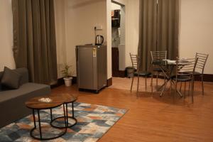 a living room with a refrigerator and a table and chairs at The Guwahati Penthouse in Guwahati