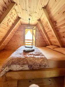 a bed in a wooden room with a window at Vila Gorska in Šavnik