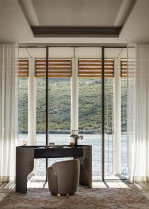 a room with a table and a chair and windows at One&Only Portonovi in Herceg-Novi