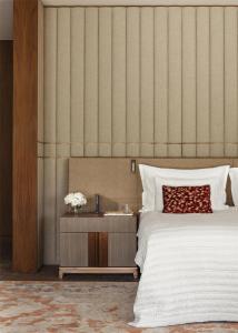 a bedroom with a bed and a table with flowers on it at One&Only Portonovi in Herceg-Novi