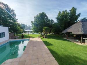 a backyard with a swimming pool and a grass yard at ASAMé @ Oppi-Rivier in Christiana